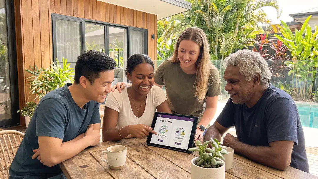 multicultural group meeting ndis A bright, airy Queensland-style home where an NDIS participant and a support worker are sharing a coffee and planning a weekly schedule on a tablet, showcasing the balance of independence and professional care.