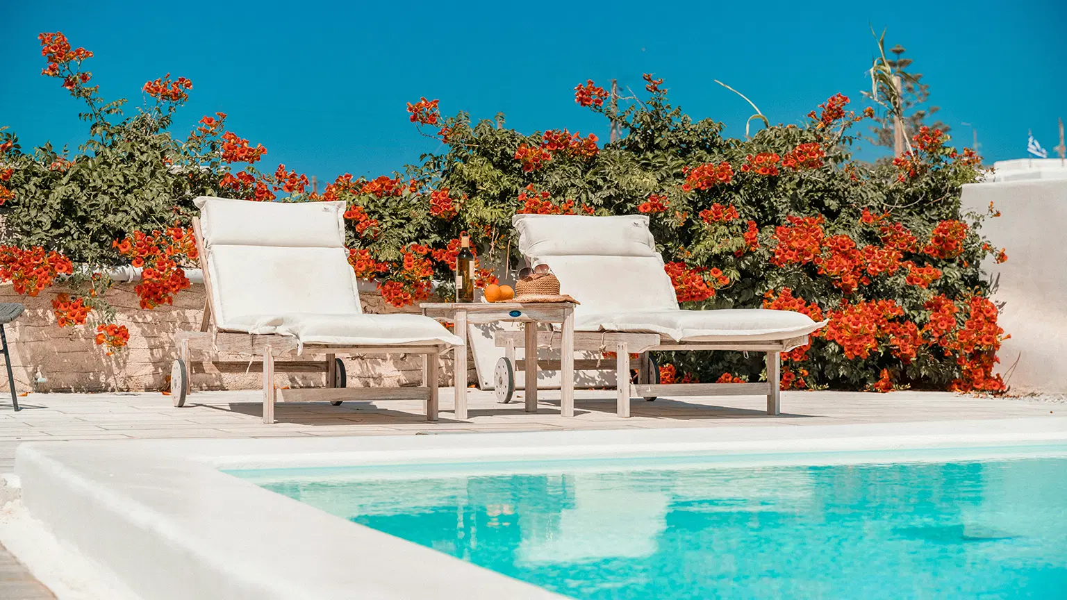 STA service image Picture of a pool with 2 relaxing chairs and flowers